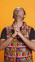 Vertikale indisch Mann Putten Hände zusammen im betteln Geste, Herstellung Wunsch, isoliert Über Studio Hintergrund. treu Person fragen zum etwas, beten und hoffend, glauben im höher Leistung, Kamera b video