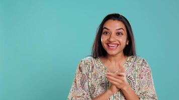 blij Indisch vrouw gelukkig klappen handen, extatisch over prestaties. opgewonden persoon reageren naar mooi zo nieuws, juichen, applaudisseren, geïsoleerd over- studio achtergrond, camera b video