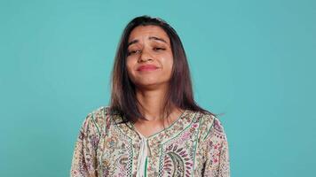 Lazy woman lacking interest for anything, feeling depressed, looking lifeless, isolated over studio background. Portrait of bored indian person suffering from tiredness, feeling exhausted, camera B video