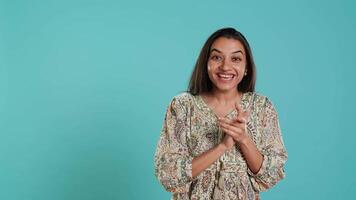 Joyful indian woman happily clapping hands, ecstatic about accomplishments. Excited person reacting to good news, cheering, applauding, isolated over studio background, camera A video