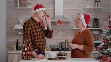 nonni con nipotina saluto a distanza madre festeggiare natale vacanza durante in linea video chiamata incontro utilizzando mobile. famiglia indossare Santa Kat godendo Natale inverno stagione