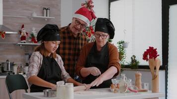 Grandparents coffee grandchild making traditional christmas homemade cookies celebrating holidays. Child using rolling pin preparing gingerbread dough dessert with bakery cookie ingredients video