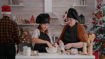 Grandchild preparing homemade cookies dough while grandmother coffee to prepare traditional holidays dessert. Family enjoying christmastime together during winter christmas holiday celebration video