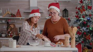 mayor mujer enseñando nieto cómo a esforzándose harina ingrediente en cuenco Cocinando tradicional festivo delicioso Galleta en culinario cocina. familia disfrutando Navidad Días festivos preparando masa video