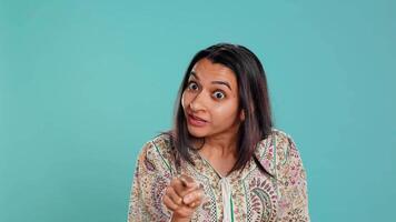 Upset indian person fighting with friend, doing scolding gesturing, isolated over studio backdrop. Annoyed woman arguing with opponent during discussion, doing admonishing hand gestures, camera B video