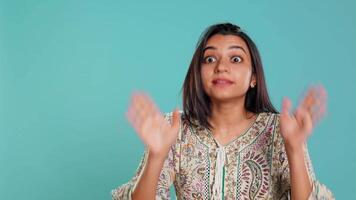 Stern indian woman doing stop hand gesture sign, complaining. Authoritative person doing firm halt sign gesturing, wishing to end concept, isolated over studio background, camera B video