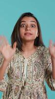 Vertical Stern indian woman doing stop hand gesture sign, complaining. Authoritative person doing firm halt sign gesturing, wishing to end concept, isolated over studio background, camera A video