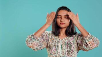 Woman covering eyes, ears and mouth, imitating three wise monkeys. Indian person doing don t see, don t hear and don t speak hand gesturing concept, studio background, camera B video
