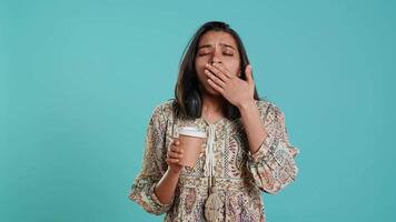 mulher sofrimento a partir de insônia bocejando, bebericando café para ganho energia e pegue livrar do dor. cansado pessoa sentindo-me sonolento depois de sem dormir noite, bebendo cafeinado bebida, estúdio fundo, Câmera uma video