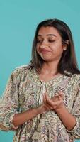 Vertikale Porträt von neidisch indisch Frau spöttisch klatschen Hände, zeigen Frustration, Studio Hintergrund. ärgerlich frech Person rollen Augen und applaudieren im Scherz, Gefühl irritiert, Kamera ein video