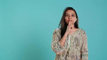 Authoritative woman doing shushing hand gesturing, demanding secrecy, irritated by noise. Stern person complaining, placing finger on lips, doing quiet warning sign gesture, studio background, camera A video