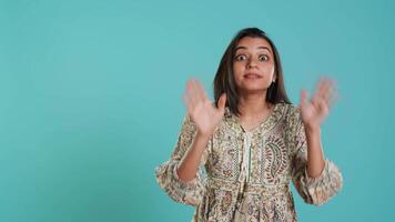 Stern indian woman doing stop hand gesture sign, complaining. Authoritative person doing firm halt sign gesturing, wishing to end concept, isolated over studio background, camera A video