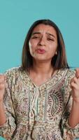 Vertical Portrait of upbeat indian woman crossing fingers, making wish, isolated over studio background. Jolly BIPOC person hoping for good luck, waiting for miracle, studio backdrop, camera A video