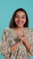 Vertical Joyful indian woman happily clapping hands, ecstatic about accomplishments. Excited person reacting to good news, cheering, applauding, isolated over studio background, camera A video