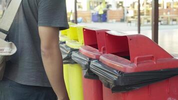 Man put empty plastic cup into the red bin video