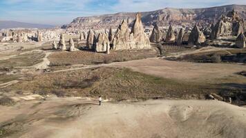 antenne dar visie van een persoon bewonderend de natuurlijk schoonheid van de roos rood vallei in Cappadocië, kalkoen. beroemd bestemming voor wandelaars naar onderzoeken de rots sites van cappadocië. video