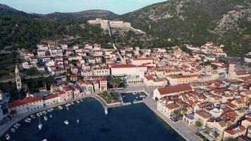 aéreo zangão Visão do a Stari grad velho cidade dentro hvar ilha dentro Croácia. barcos em a doca dentro a adriático mar. video