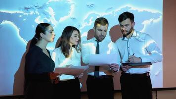 grupp av ny generation diskuterar handla om förnybar energi på möte rum med värld Karta på bakgrund. global uppvärmningen förorening växthus effekt begrepp video