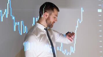 Confident professional businessman looking at the time with stock trade graph in background video