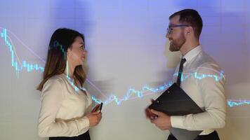 Business partners man and woman are discussing an investment deal. Handshake over the stock market chart video
