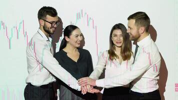 Corporate business team people group stacks hands together in pile with cryptocurrency chart on background. Leadership and teamwork spirit concept video