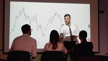 Confident professional business speaker welcomes the participants in the meeting. Young trader presents cryptocurrency investment strategy for group of investors on candlestick chart video