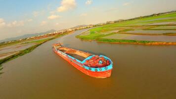 fpv vuelo terminado un grande barcaza en un río canal en ninh bin, Vietnam. video