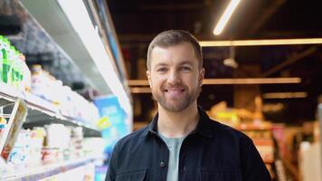 portret van een Mens Bij supermarkt. Mens kiezen de Rechtsaf Product in een supermarkt video