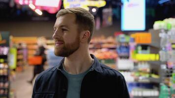 caucasien homme des promenades à épicerie supermarché et choisir le droite produit video