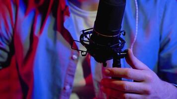 Blogger or radio DJ recording in studio. Close up of vlogger using microphone and headphones to record vlog for channel video