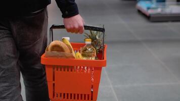 un' uomo con shopping cestino passeggiate a drogheria supermercato. uomo la scelta il giusto Prodotto nel un' supermercato video