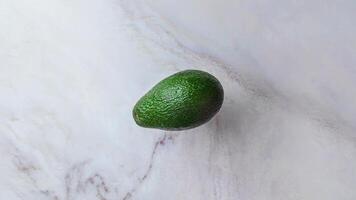 avocado jumps and falls into slices on a marble table, background creative stopmotion video animation footage