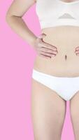 dames lichaam figuur in wit ondergoed krijgen dik en verliezende gewicht animatie Aan een roze achtergrond. gif 4k verticaal video