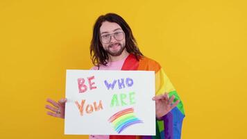 Young transsexual transgender man holding paper with love is love message. Doubt concept video