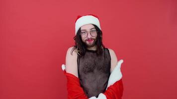 retrato do uma transexual nosso andrógino homem em uma vermelho fundo. gay dentro a terno do santa claus video