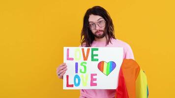 Young transsexual transgender man holding paper with love is love message. Doubt concept video