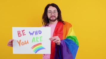 amor é amar. atraente gay caucasiano homem segurando uma protesto placa durante uma lgbt orgulho parada video