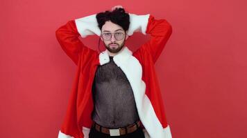 portret van een gebaard homo Mens Aan een rood achtergrond. homo in de pak van de kerstman claus. thema van gelijkheid en vrijheid van keuze video