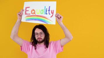 Young transsexual transgender man holding paper with equality message. Doubt concept video