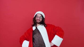 Porträt von ein Fröhlich Mann auf ein rot Hintergrund. Fröhlich im das passen von Santa claus video