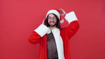 retrato de un gay hombre en un rojo antecedentes. gay en el traje de Papa Noel noel tema de igualdad y libertad de elección video