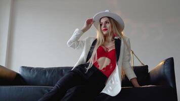 Fashionable and stylish woman in white hat, jacket and red bra with red lips makeup. Fashion look, beauty and style video