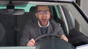 Funny man sits in a new car in shop dealership and yawns video
