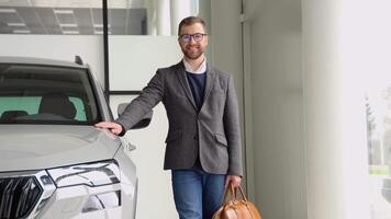Portrait of a stylish man with a bag in a car dealership video
