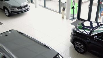WOLFSBURG, GERMANY, DEC 10, 2022. Caucasian man in glasses and suit goes to the car dealership to buy a new car video