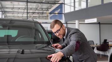 un' uomo esamina il suo nuovo elettrico macchina. auto attività commerciale, auto saldi, tecnologie e persone concetto video