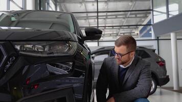 A man examines his new luxury car. Auto business, car sale, technologies and people's concept video