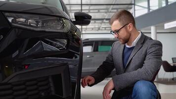 A man examines his new luxury electric car. Auto business, car sale, technologies and people's concept video