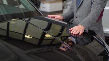 Close up of a man examines his new car. It's always pleasure to buy a car on a right place video