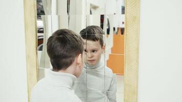 Boy playing with distorted mirror in museum of science while school excursion video